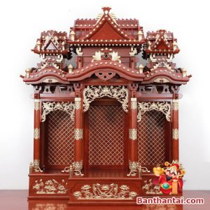 Mặt chính diện của bàn thờ Thần Tài nổi bật với thiết kế ba gian mái chồng diêm, chạm trổ tinh xảo và dát vàng thủ công