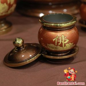 Chén đồng đỏ khắc chữ “Phật” và hoa sen vàng nổi bật
