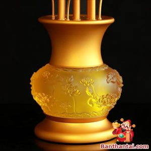 Thân bình chạm nổi họa tiết sen, màu vàng mờ hài hòa ánh sáng đèn
